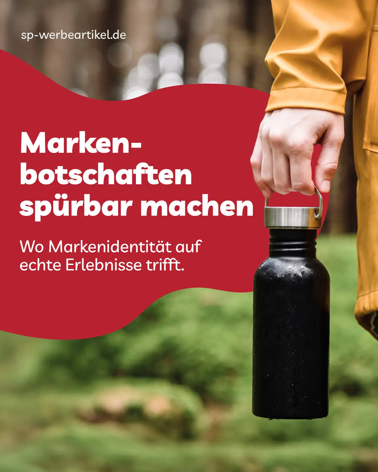 Eine Hand hält eine schwarze Trinkflasche mit Henkel